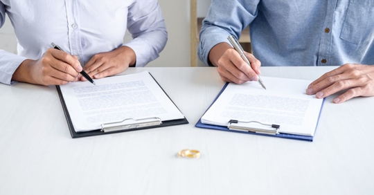 divorced couple signing papers
