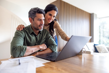 happy couple looking at laptop