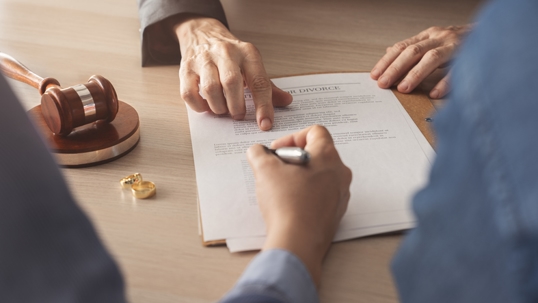 couple signing divorce papers in lawyer's office